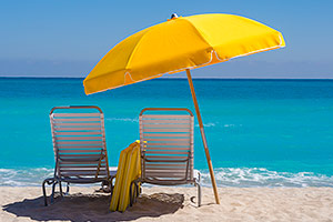 Beach chairs under the shade of an umbrella